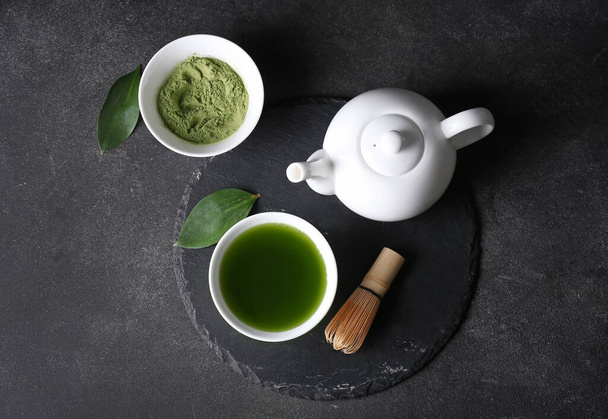 Composition with bowl of matcha tea and powder on dark background - Fotó, kép