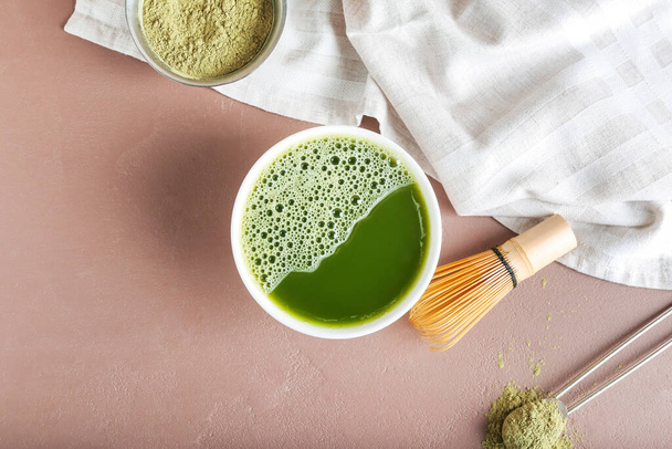 Composition with bowl of matcha tea, chasen and powder on color background - Фото, изображение