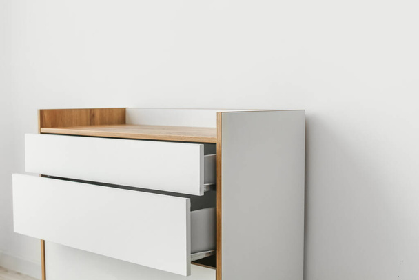 Modern chest of drawers near light wall in room - Photo, image