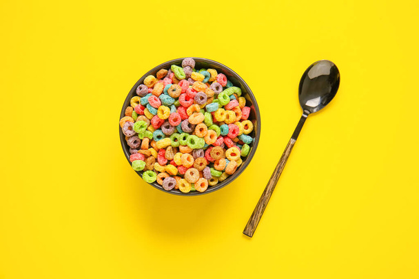 Bol et cuillère avec anneaux de céréales sur fond de couleur - Photo, image