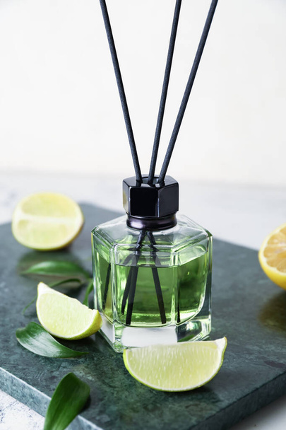 Reed diffuser with lemon and lime on light background - Photo, Image