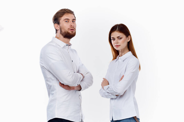 Μια γυναίκα και ένας άντρας με άσπρα πουκάμισα στέκονται ο ένας δίπλα στον άλλο με τα χέρια σταυρωμένα στο στήθος. - Φωτογραφία, εικόνα