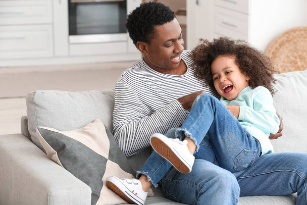 Glücklicher afroamerikanischer Vater und seine kleine Tochter spielen zu Hause - Foto, Bild