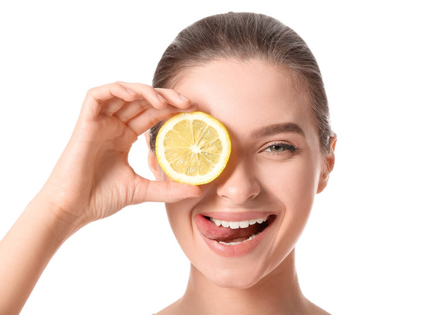 Beautiful young woman with cut lemon on white background - Photo, Image