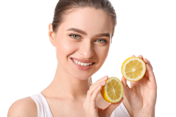 Beautiful young woman with cut lemon on white background - Foto, afbeelding