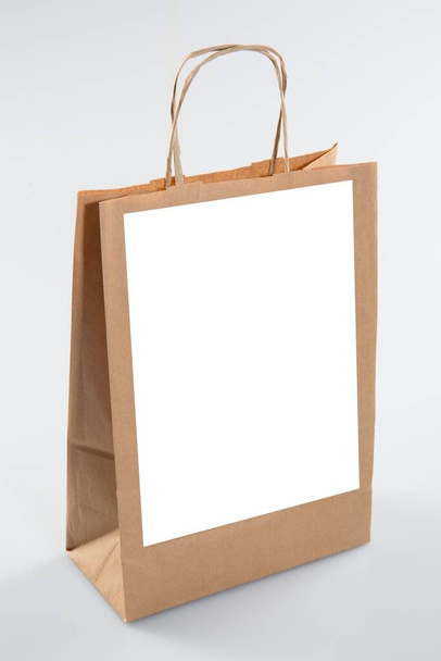Переработанный бумажный крафт покупки большой коричневый бумажный пакет для продуктов питания с чистым листом бумаги для текста макет пустое белое пространство для логотипа бренда изолированы на белом фоне - Фото, изображение