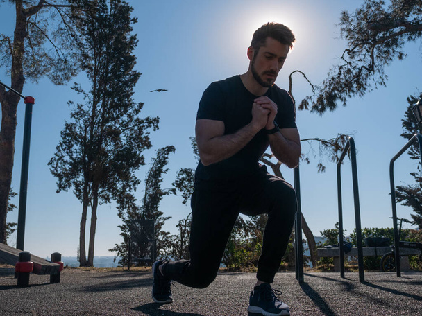 A young Caucasian man from Spain training calisthenics in a park on a sunny spring day - Foto, afbeelding
