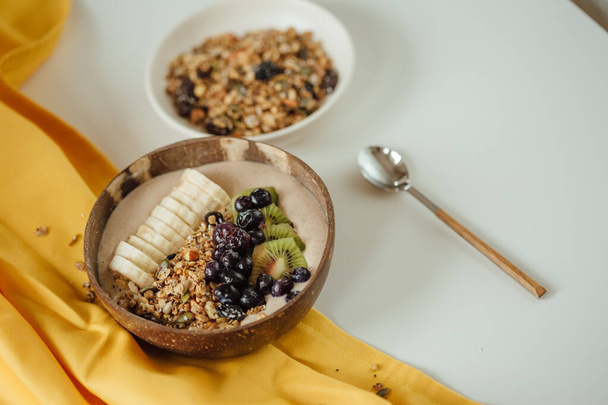 A shot of a plate coconut plate with a tasty smoothie bowl. - 写真・画像