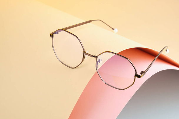 Mode trendige Brille zur Korrektur des Sehvermögens auf kreativem Hintergrund, Welle aus Papier, bunter Hintergrund, Kopierraum - Foto, Bild
