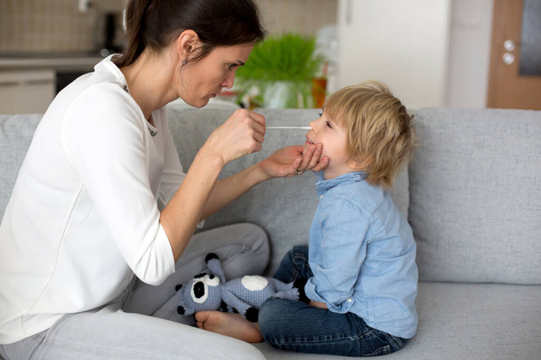 Mother, testing her child for covid at home, making home allowed swab tests to prove negative result - Foto, Imagen