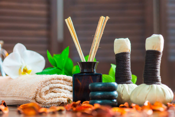 Spa background. Towel, candles, flowers, aroma sticks, massaging stones and herbal balls. Massage, oriental therapy, wellbeing and meditation. - Фото, изображение