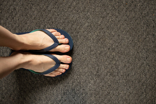 női láb nyáron kék strand flip papucs áll a padlón - Fotó, kép