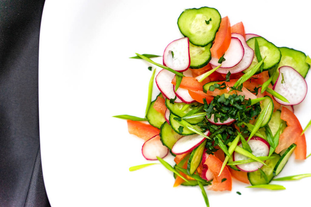 Healthy salad with tomatoes, cucumbers, onions and radishes in Minsk. Healthy snack concept. Keto, a paleo-eater. Top view, overhead, copy space - Photo, Image