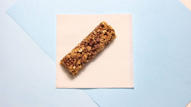 One whole energy bar on a paper napkin. The concept of sports nutrition. Top view. - Foto, Imagen