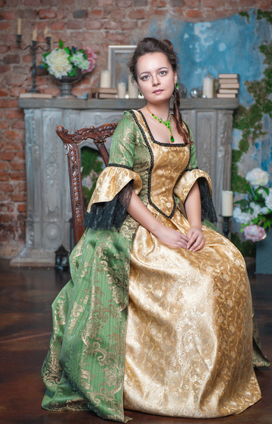 piękna kobieta w średniowiecznych sukienka na krzesło - Zdjęcie, obraz