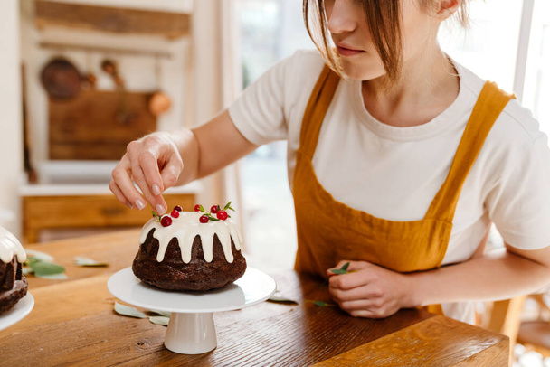 Beautiful concentrated pastry chef woman making chocolate cake at cozy kitchen - Fotó, kép