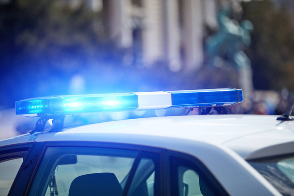 Polizeiauto mit Blaulicht am Tatort im verkehrsberuhigten Stadtgebiet. - Foto, Bild