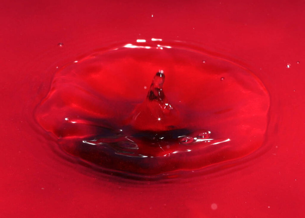 drop of red liquid on the surface of toxic water - Foto, afbeelding