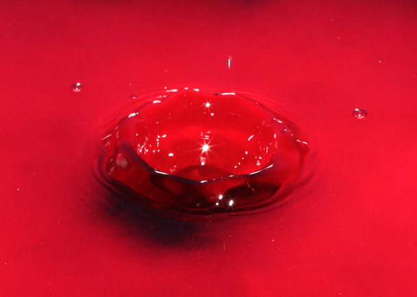 drop of red liquid on the surface of toxic water - Foto, Imagen