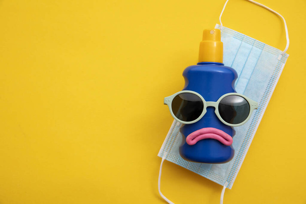 Coronavirus summer background. Sun cream face with sunglasses and face mask - Zdjęcie, obraz