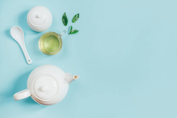 bovenaanzicht van een set theegerei theepot suikerpot kop met thee op een blauwe achtergrond - Foto, afbeelding