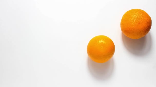 Остановите анимацию движения. Два спелых апельсина движутся на белом фоне. Крупный план. - Кадры, видео
