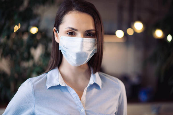 Potrait of a young beautiful businesswoman wearing medical face mask - Foto, afbeelding