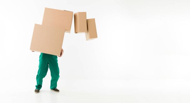 unrecognizable man holding stack of cardboard boxes, dropping some of them - Foto, afbeelding