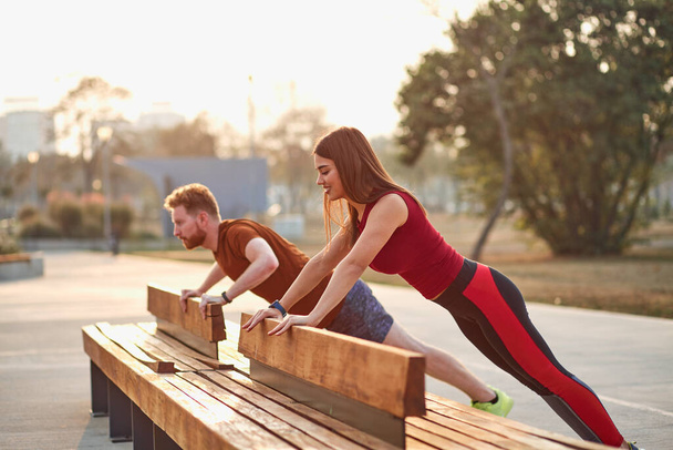 Dva mladí sportovní muž a žena cvičení v městském parku. - Fotografie, Obrázek