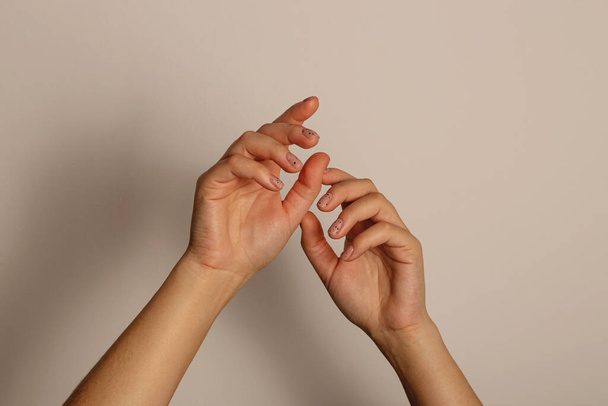 Womens hands reach up. With minimalistic manicure on a dark background - Zdjęcie, obraz