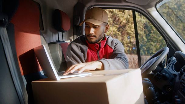 Кур'єр використовує ноутбук у фургоні для підтвердження адреси доставки
 - Фото, зображення