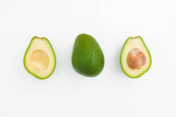Фрукты авокадо цельные и половина на белом фоне. Концепция продуктов питания. - Фото, изображение