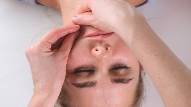 Чін масаж жінки молода жінка під час масажу обличчя в салоні краси
 - Фото, зображення