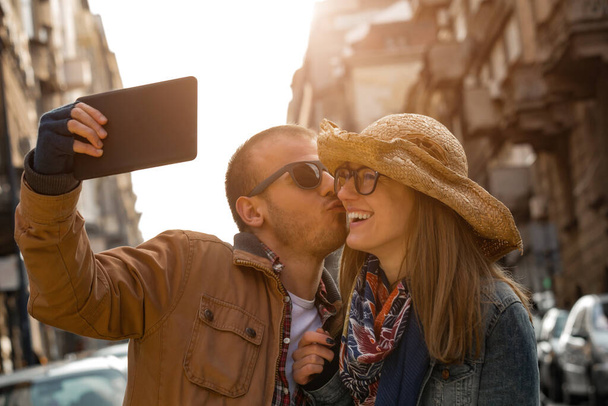 Νεαρό ζευγάρι βγάζει selfie στο δρόμο στην αστική περιοχή. - Φωτογραφία, εικόνα