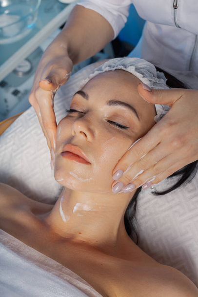 Професійна красива жінка масажує обличчя до клієнта
. - Фото, зображення