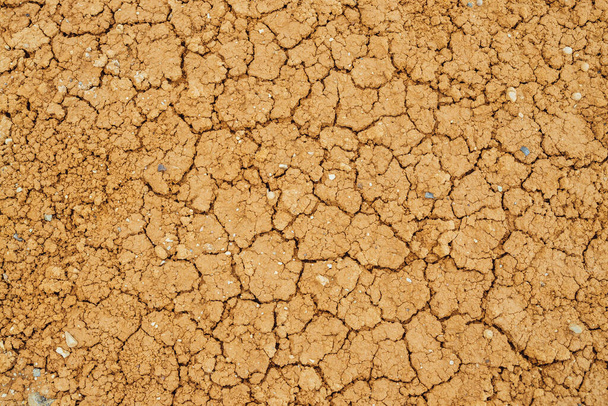 亀裂乾燥した土地の自然背景。き裂のある土の自然な質感。不毛の乾燥地の荒地の閉鎖の壊れた粘土表面。乾燥した気候の地形への完全なフレーム。地球上の生命のない砂漠 - 写真・画像