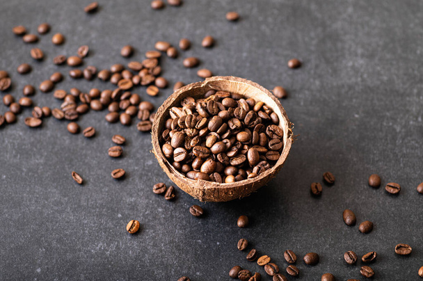 mustat kahvipavut arabica, aromaattinen kookoskulhossa, sirotellut pavut pöydälle - Valokuva, kuva