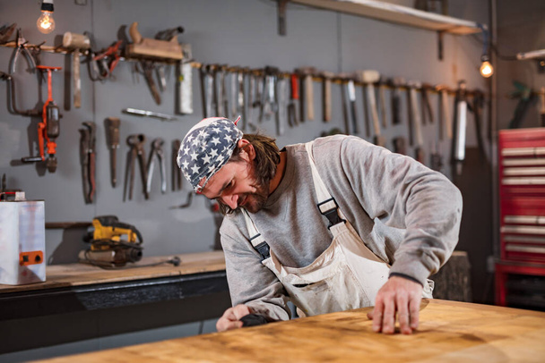 Carpintero macho trabajando en madera vieja en un taller retro vintage. - Foto, Imagen
