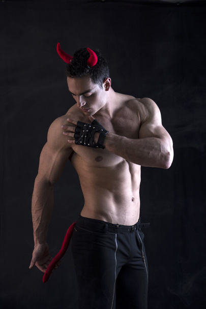 Shirtless muscular male bodybuilder dressed with devil costume - 写真・画像
