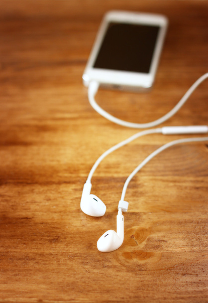 Earphones attached to smartphone. - Foto, Bild