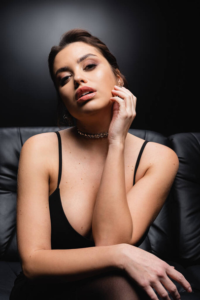 seductive woman in necklace, earrings and slip dress on black - Photo, Image