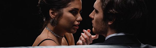 sexy woman seducing man isolated on black, banner - Foto, afbeelding