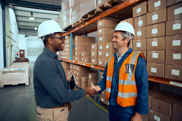 Multiracial engineers shaking hands with each others at manufacturing industry - Photo, Image