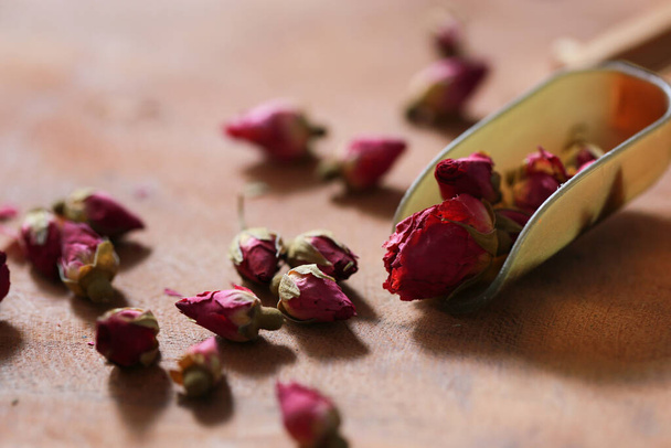 Té rosa con vidrio transparente y jarra con flor de rosa seca sobre tabla de madera. Aroma rosa bebida caliente para saludable por el té de flores. - Foto, imagen