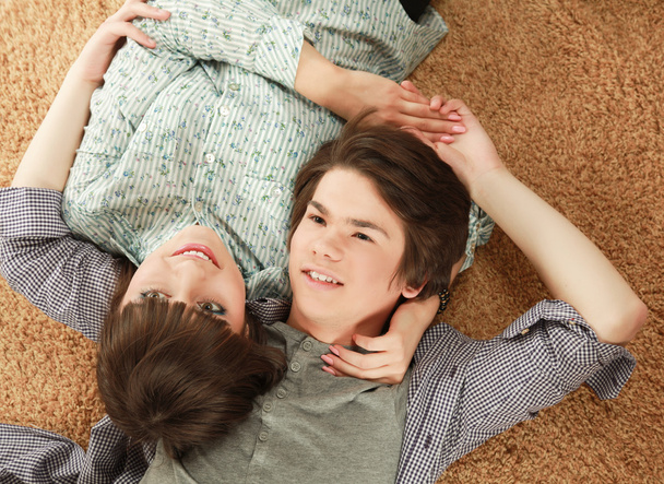 A young couple lying on the floor - 写真・画像