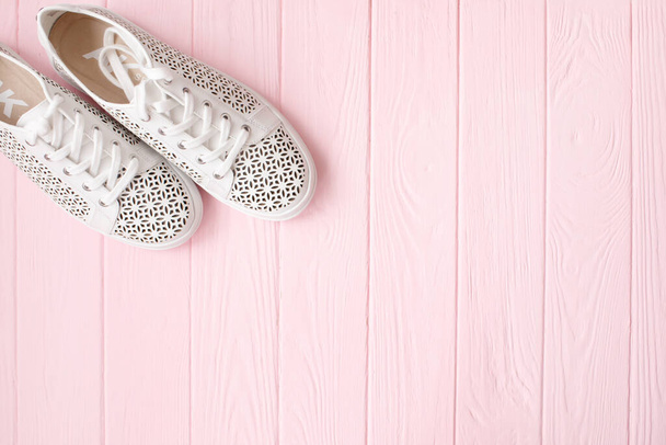 top view of white stylish shoes on pink wooden background with copy space  - Photo, image