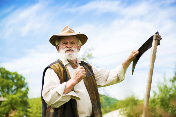 Farmer with scythe - Фото, изображение