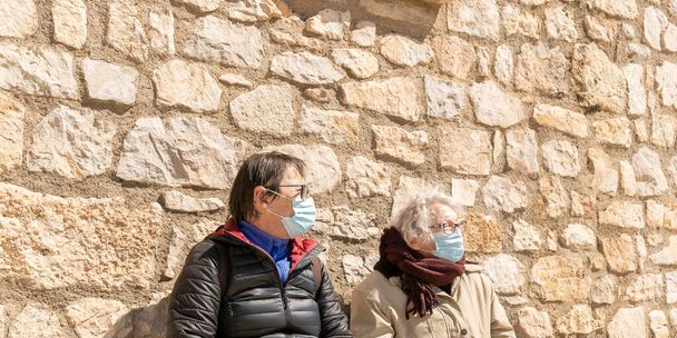 Covid-19 salgını sırasında koruyucu maske takan iki yaşlı kadının portresi.. - Fotoğraf, Görsel