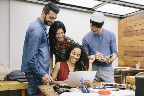 Négy többnemzetiségű ember elindítása, akik örömteli ötleteket vitatnak meg egy modern coworking tempóban - Fotó, kép