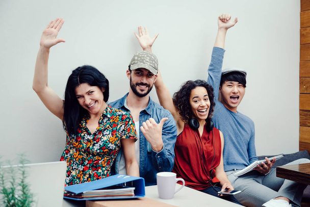 Grupo de cuatro emprendedores multiétnicos celebrando el éxito de su nueva empresa - Foto, imagen